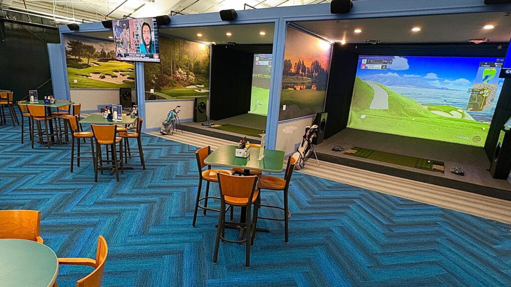 The SimZon room with bays, high-top tables and lounge seating